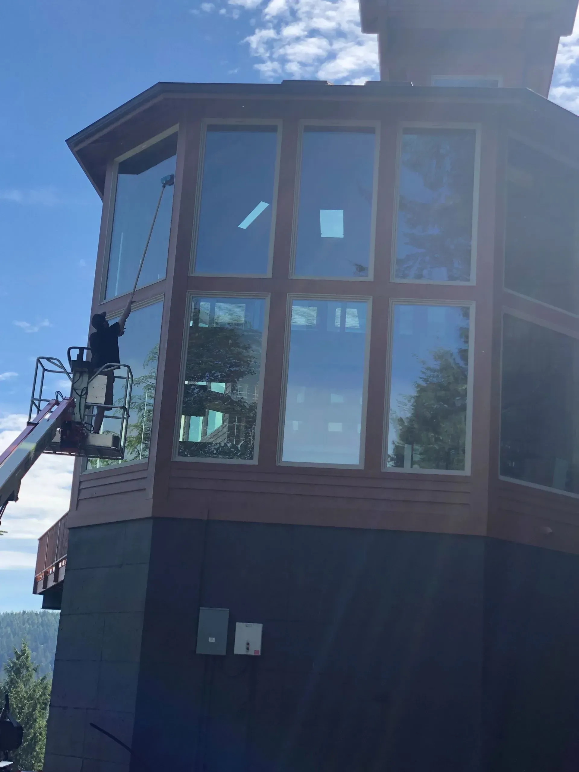A man is cleaning the windows of a large building.