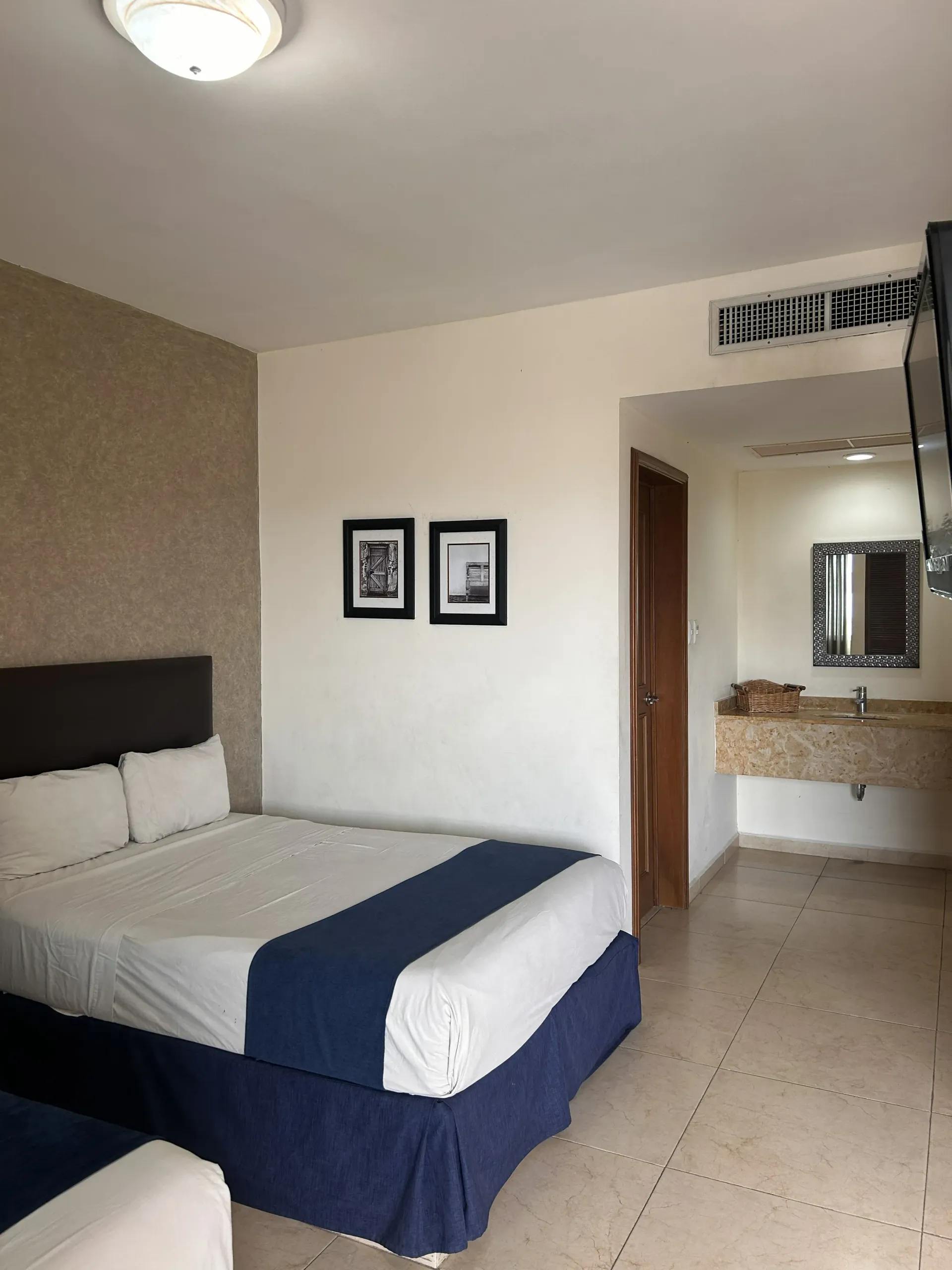 Una habitación de hotel con una cama tamaño queen, una alfombra azul.