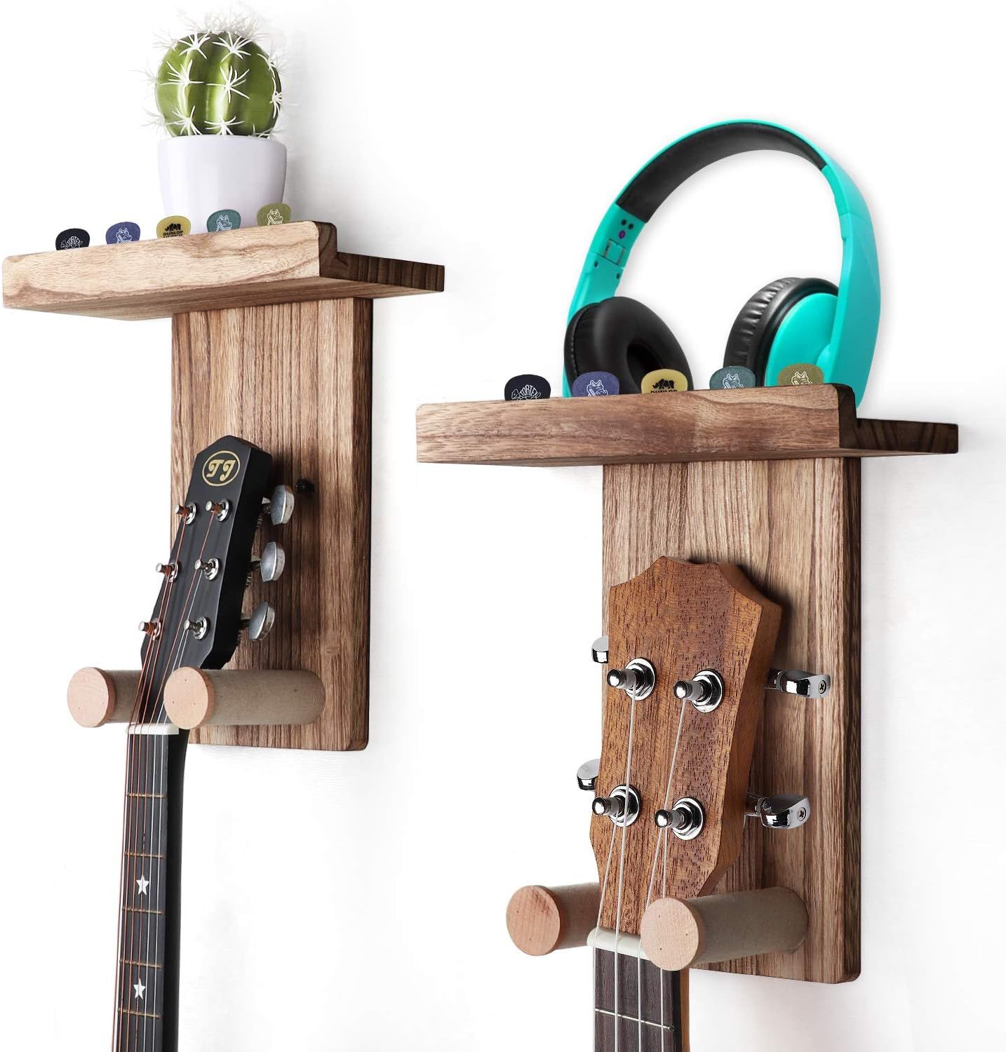 Dos soportes de pared rústicos de madera para guitarras, con guitarras y un pequeño cactus en el estante.
