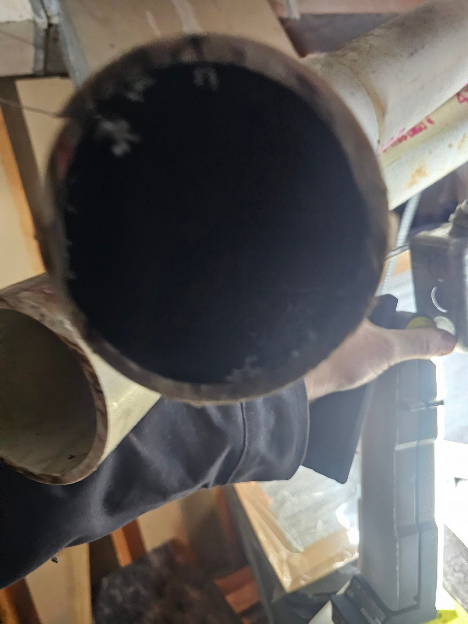 A person is holding a large pipe in their hand.