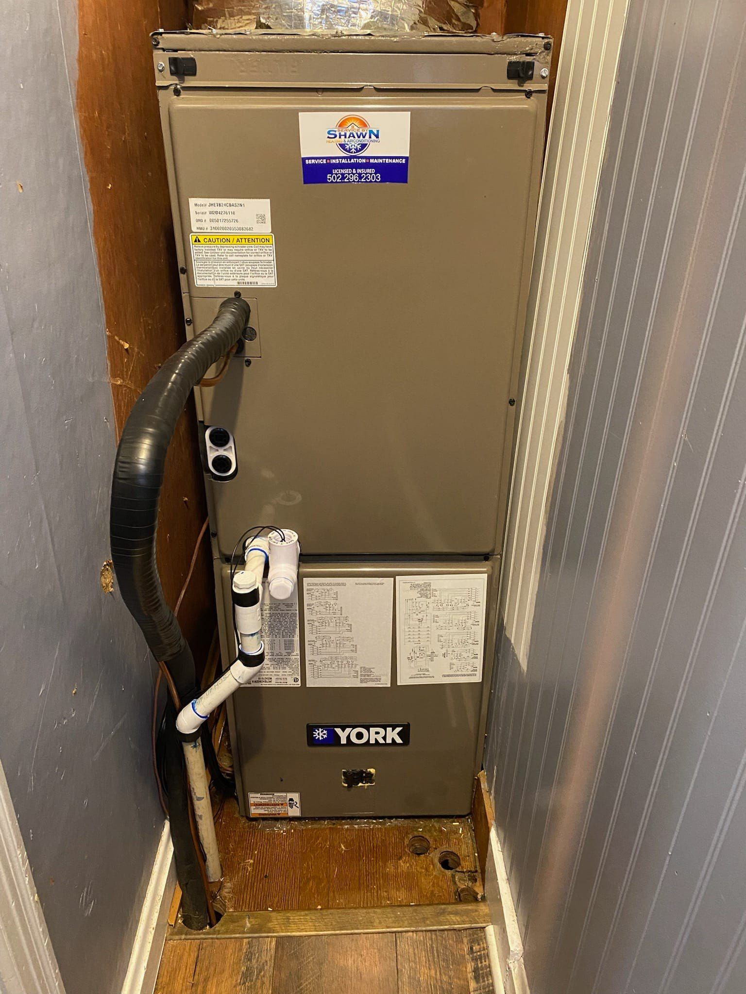 An air conditioner is sitting in a corner of a room.