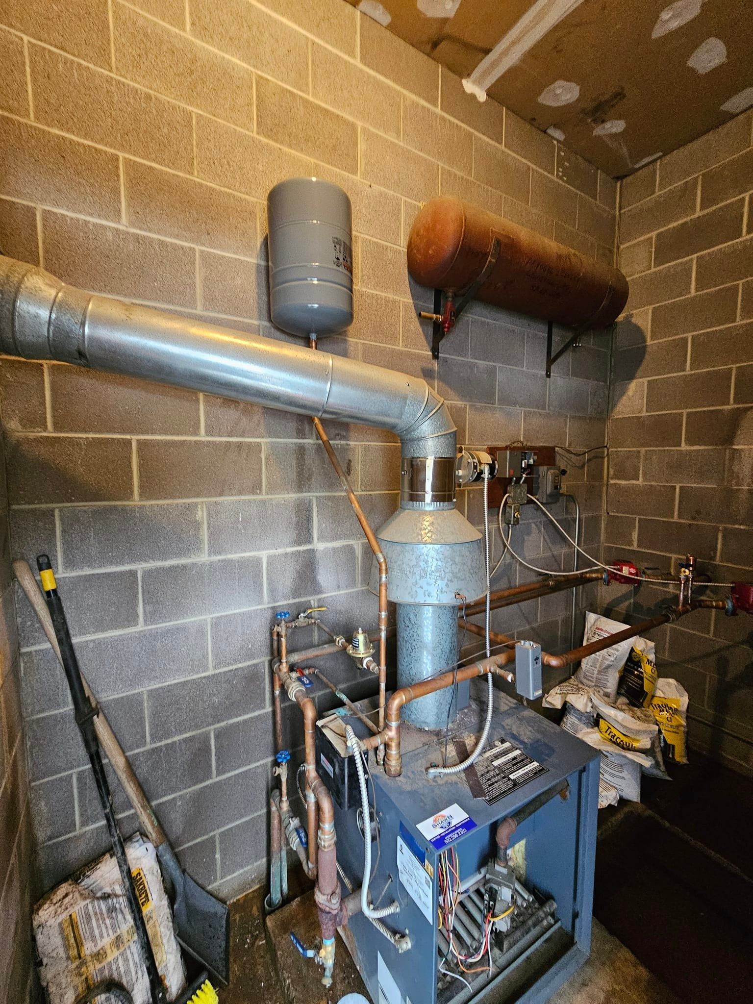 A room with a stove and pipes in it.