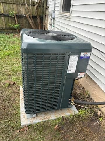 An air conditioner is sitting on the side of a house.