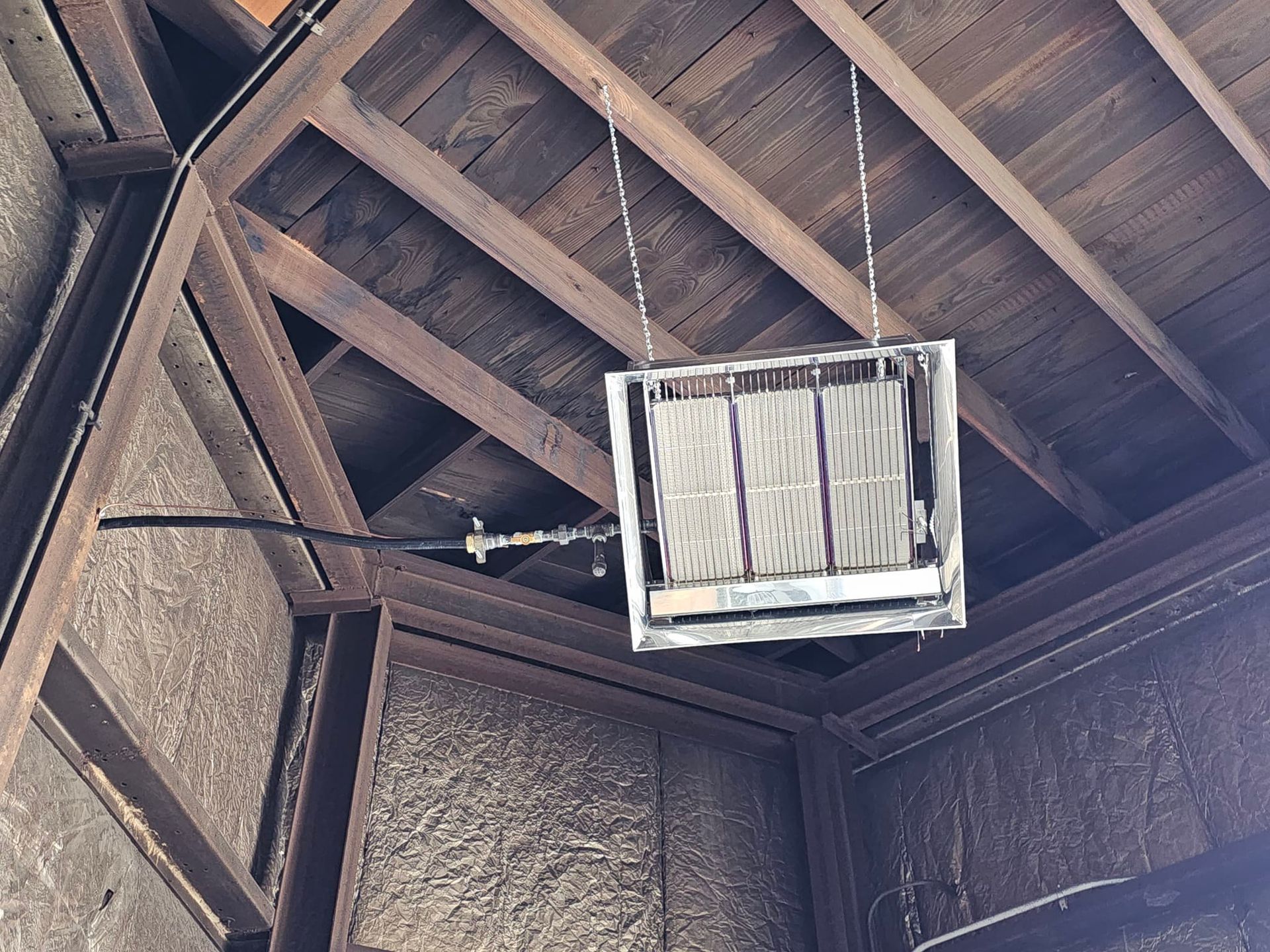 A heater is hanging from the ceiling of a building