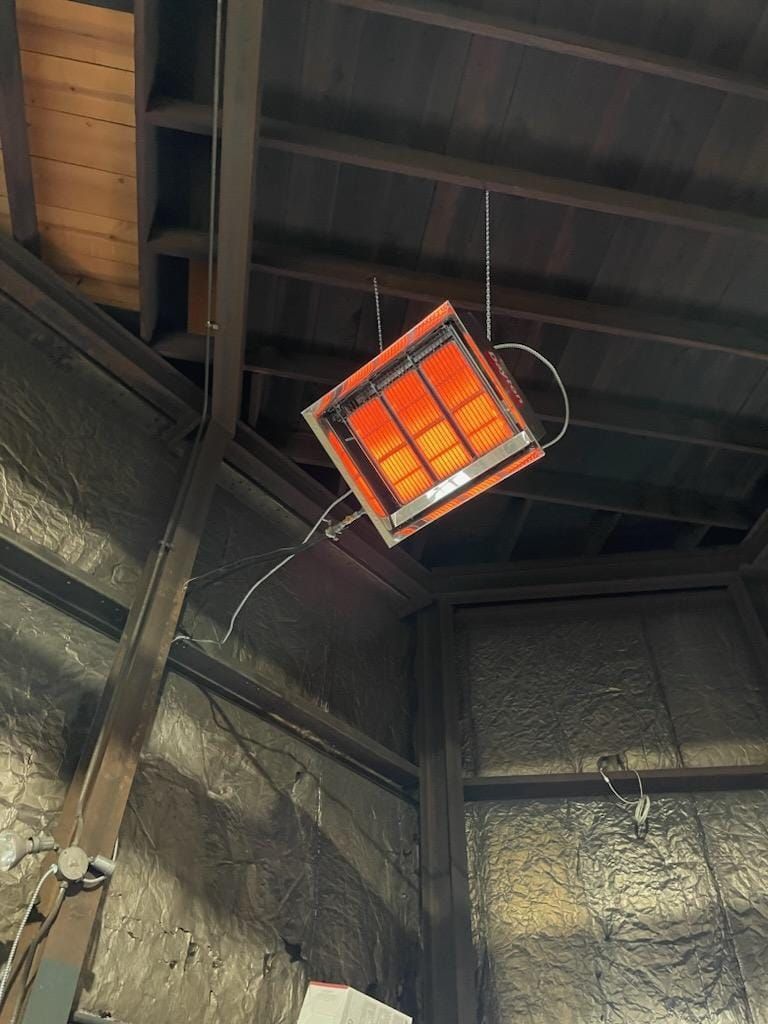 A heater is hanging from the ceiling of a building.