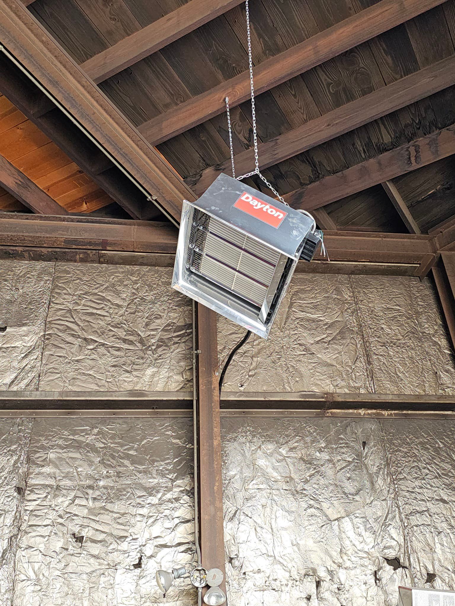 A heater is hanging from the ceiling of a building.