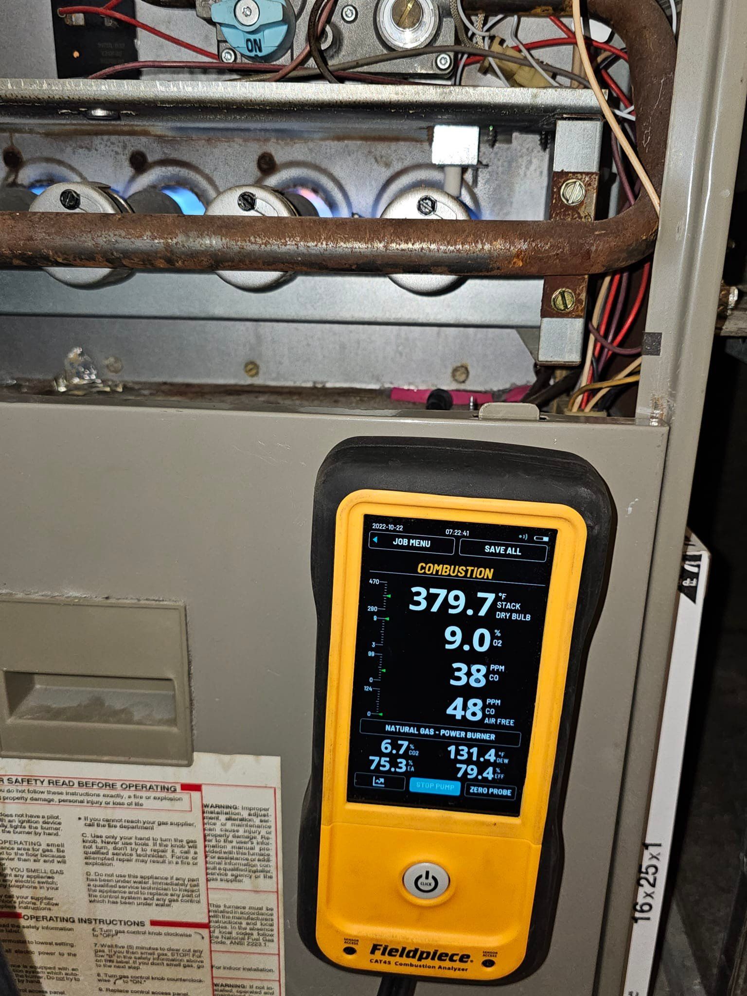 A yellow and black device is sitting on top of a heater.