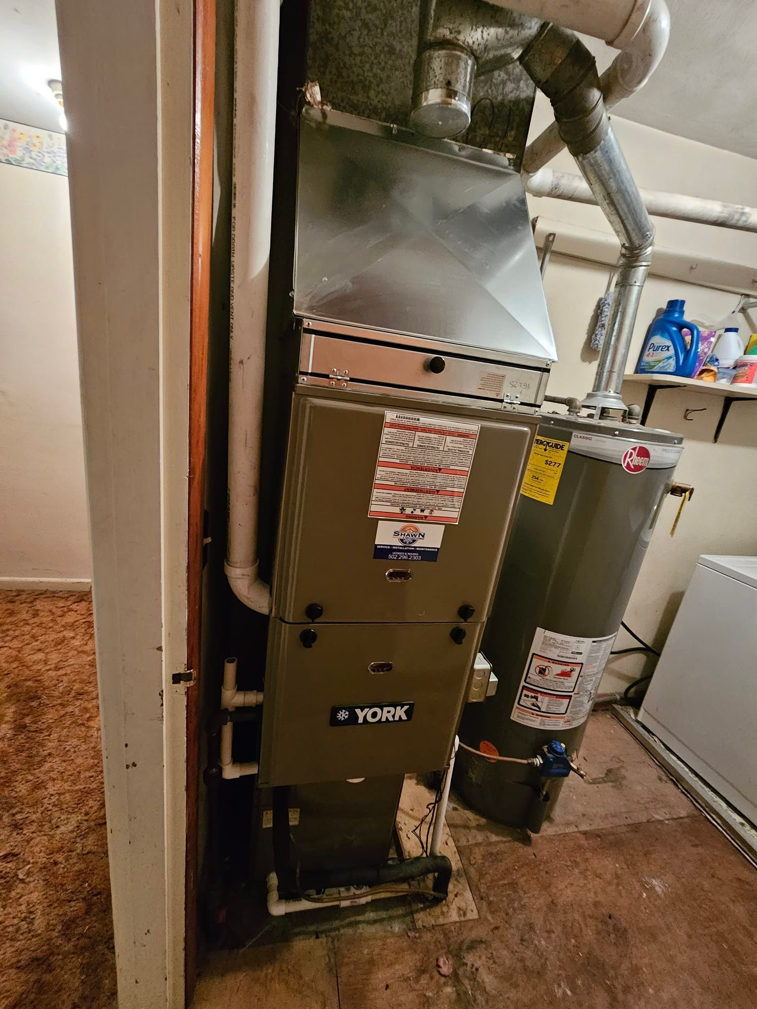 An air conditioner and a water heater are sitting next to each other in a room.