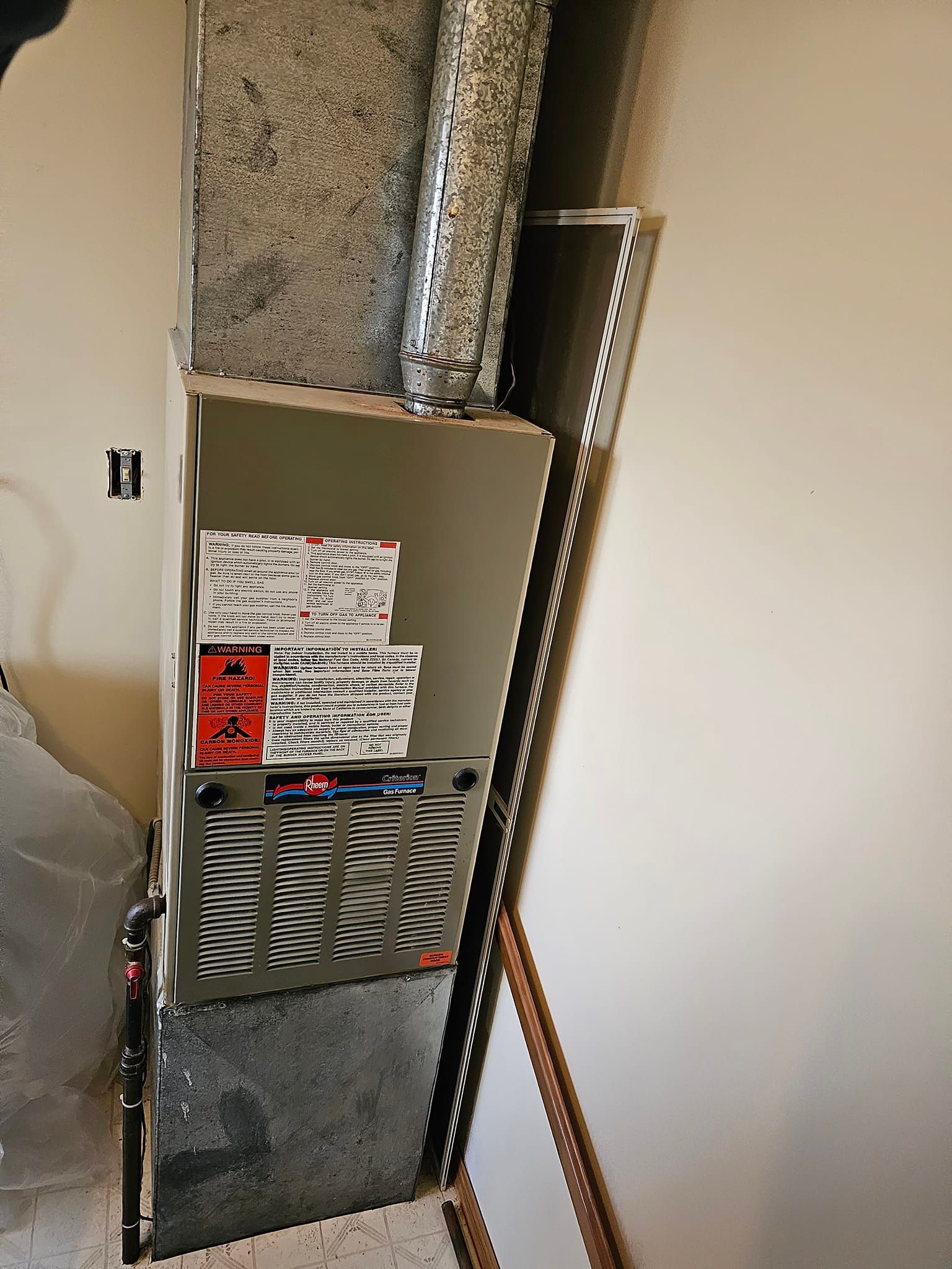 An air conditioner is sitting in a room next to a wall.