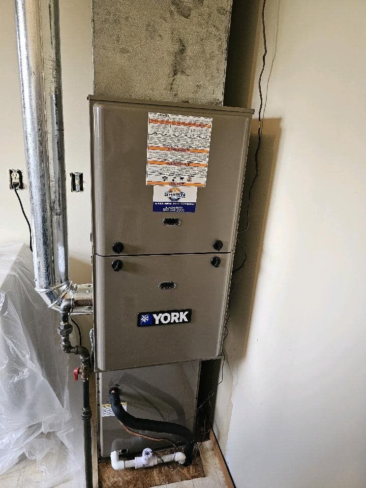 A york air conditioner is sitting in a room next to a wall.