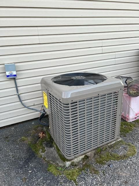 An air conditioner is sitting on the side of a building.
