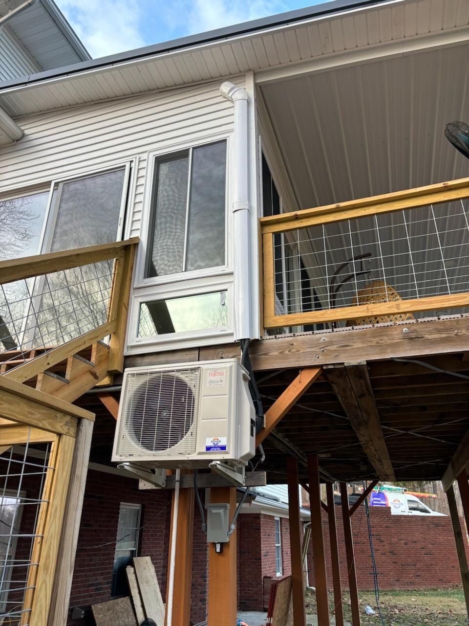 A large air conditioner is mounted on the side of a house.