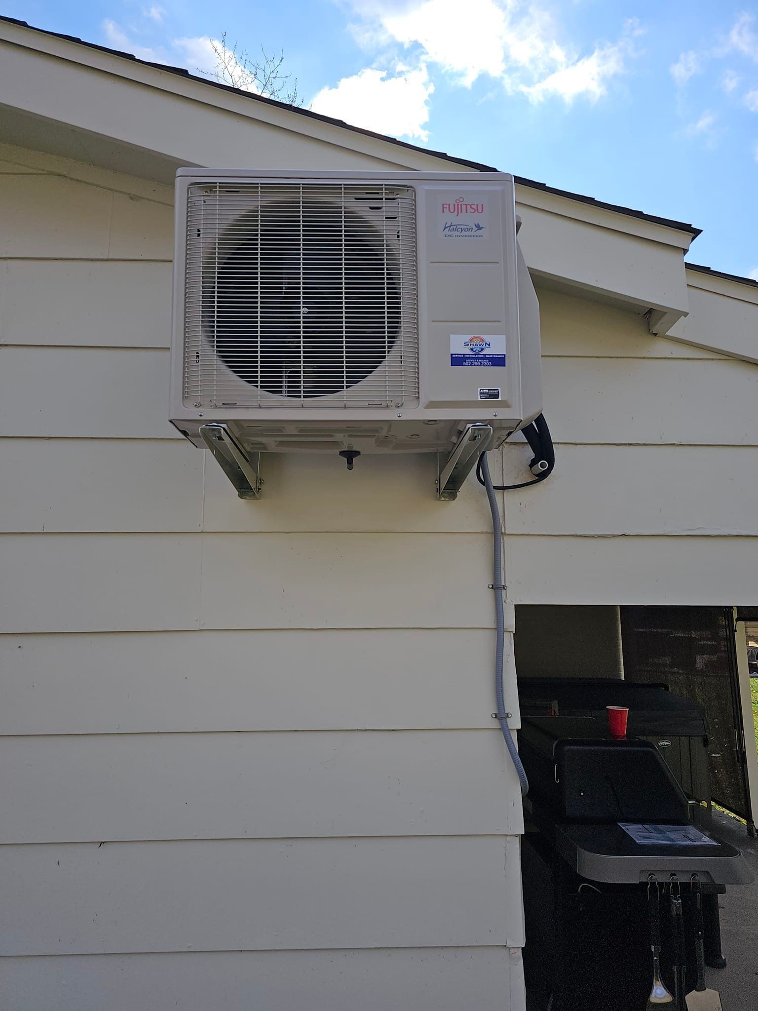 An air conditioner is mounted on the side of a house