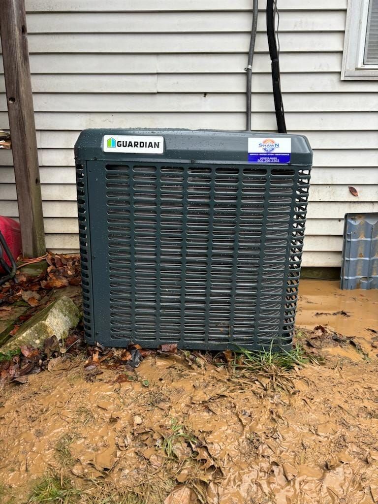An air conditioner is sitting on the side of a house.