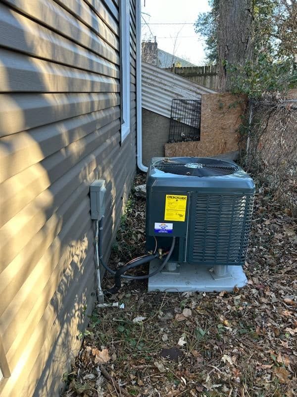 An air conditioner is sitting on the side of a house.