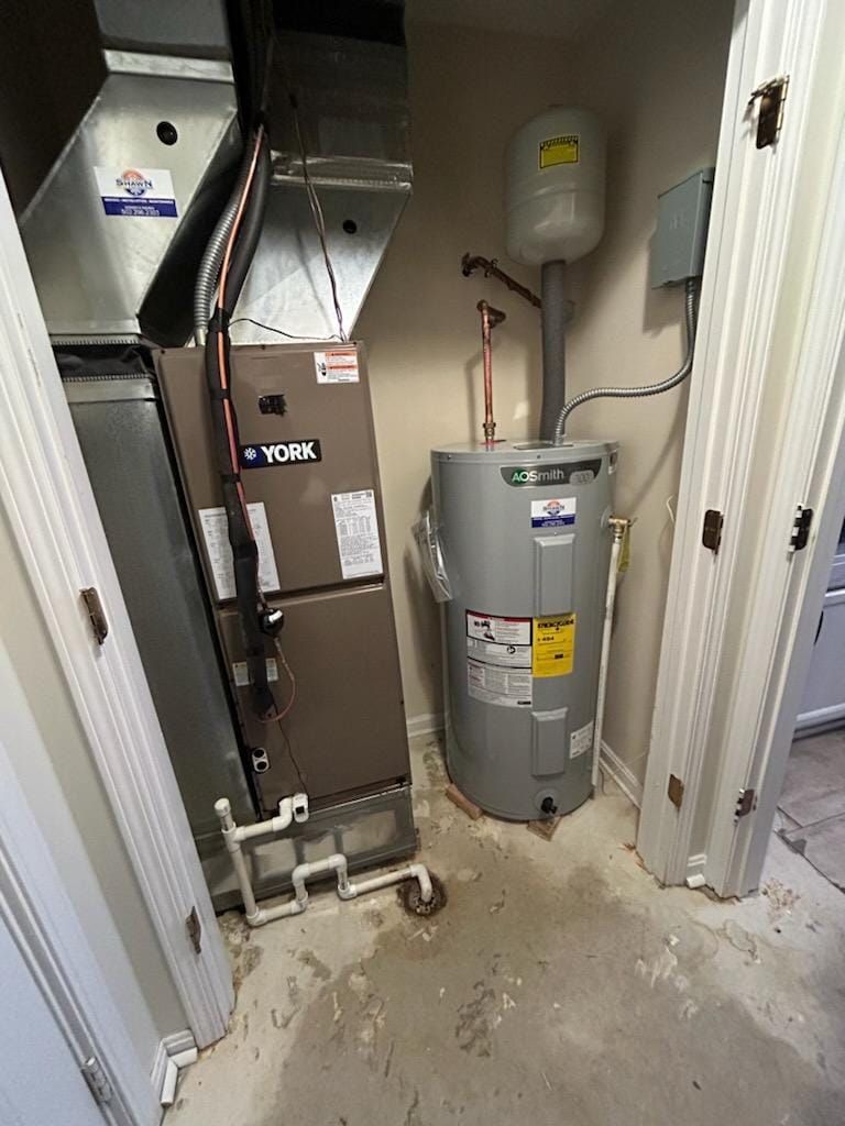 A room with a water heater and a furnace in it.