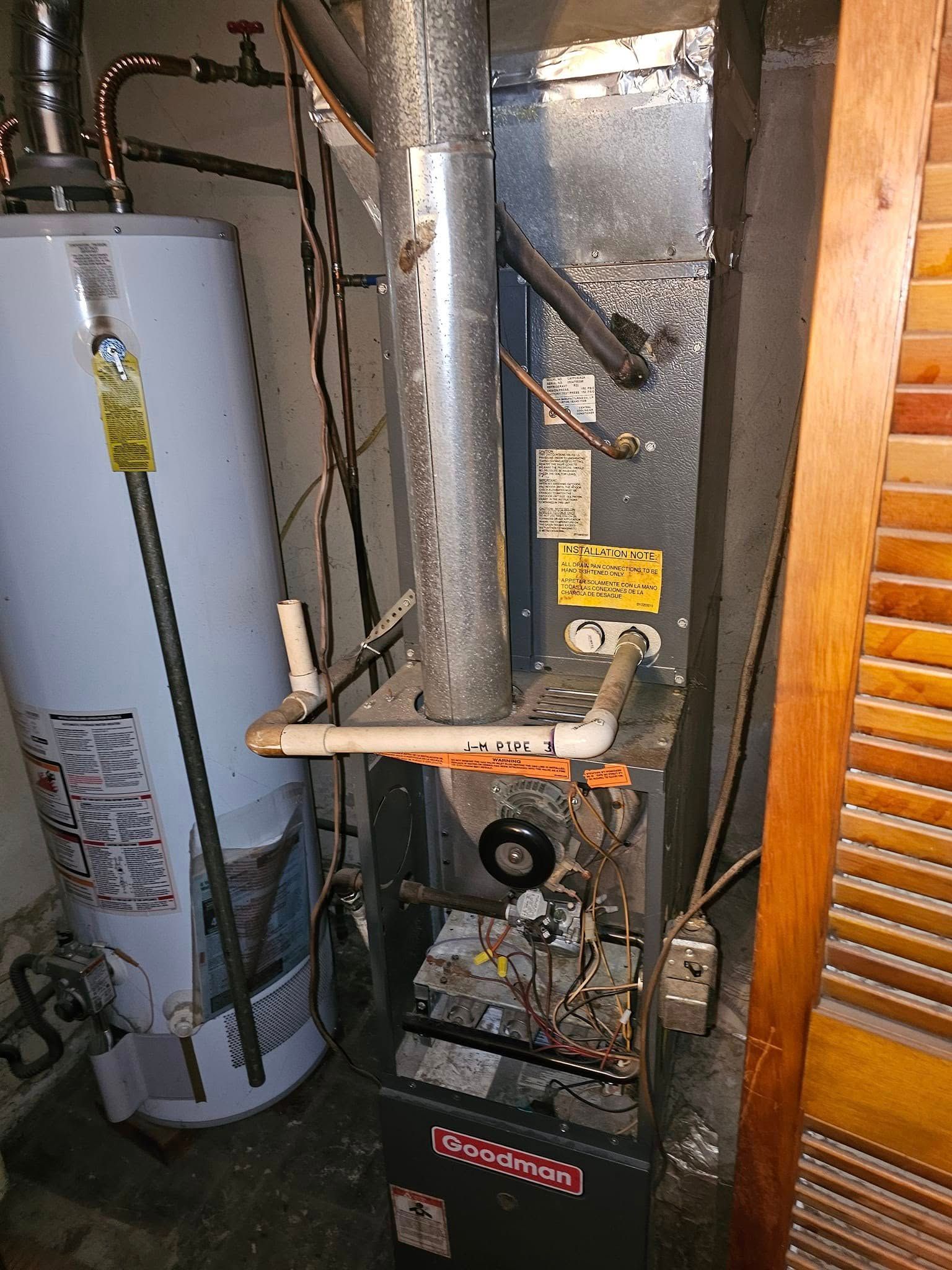 A water heater and an air conditioner are sitting next to each other in a room.