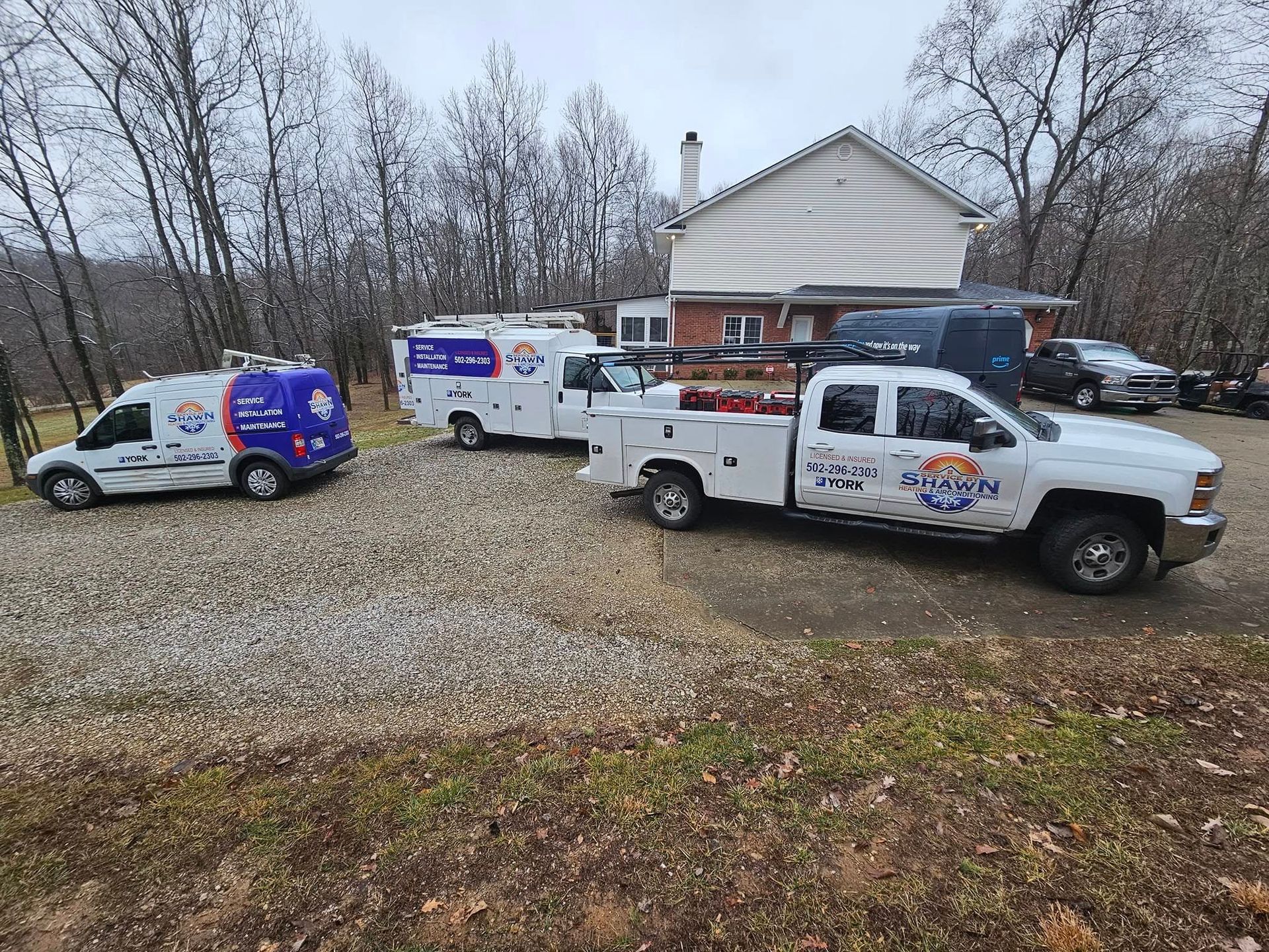 Three trucks are parked in front of a house.