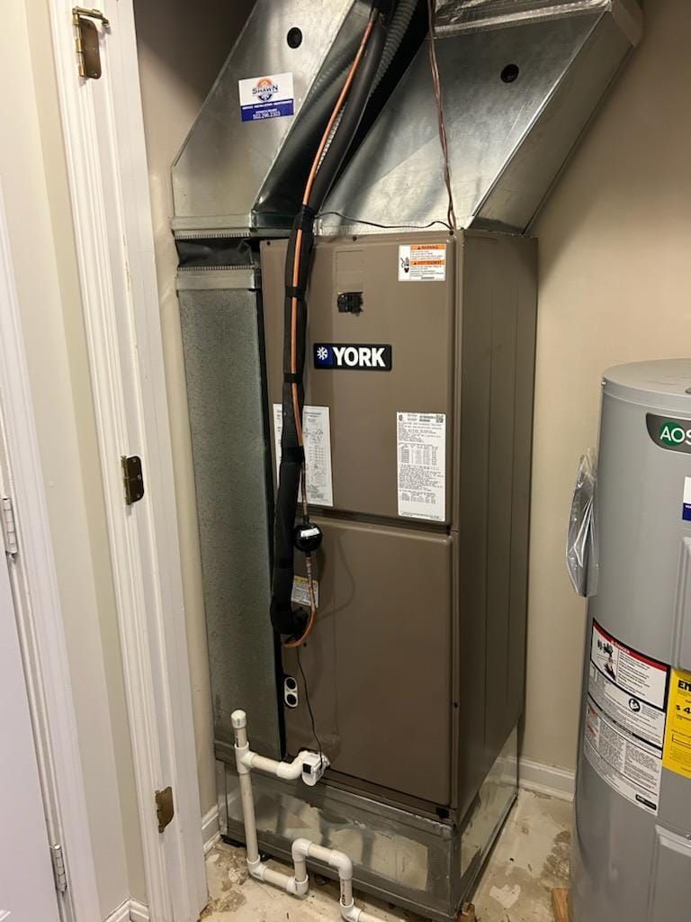 A york air conditioner is sitting in a room next to a water heater.