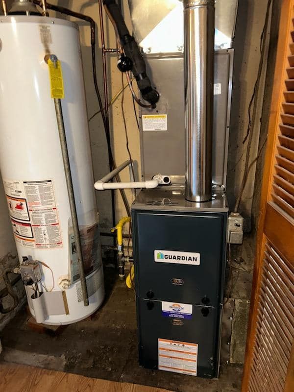 A water heater and a furnace are in a basement.