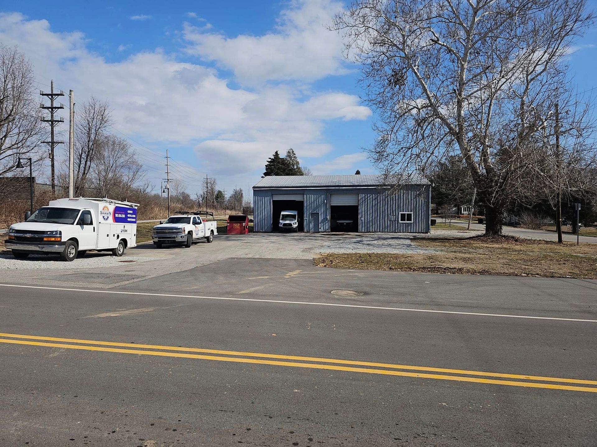An ambulance is parked in front of a garage on the side of the road.