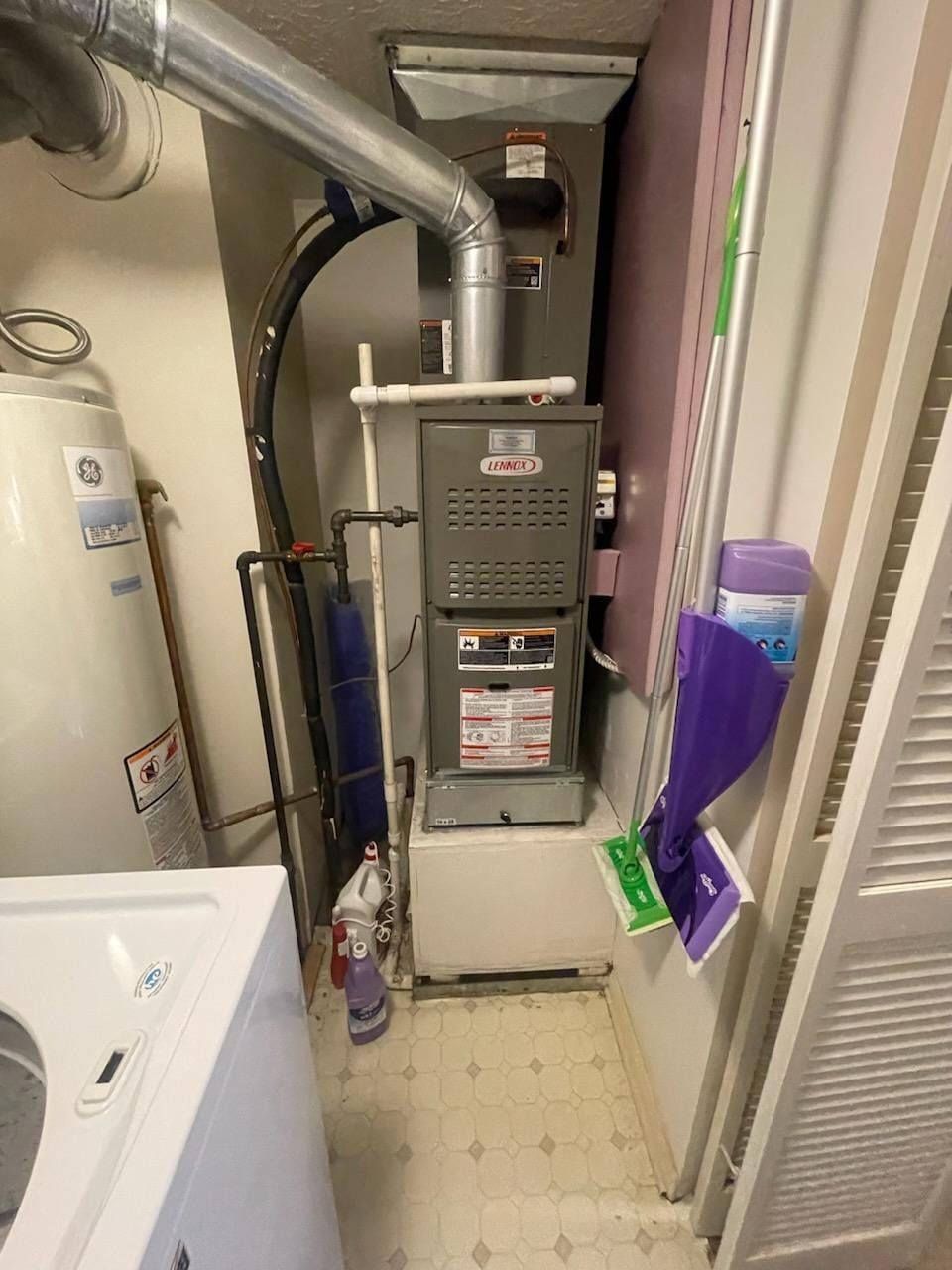A laundry room with a washer and dryer and a furnace.