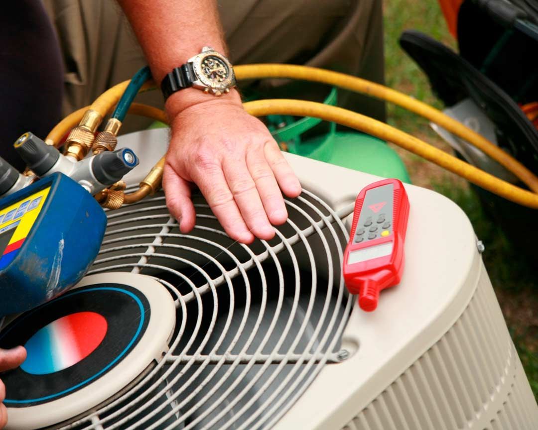 A man wearing a watch is working on an air conditioner