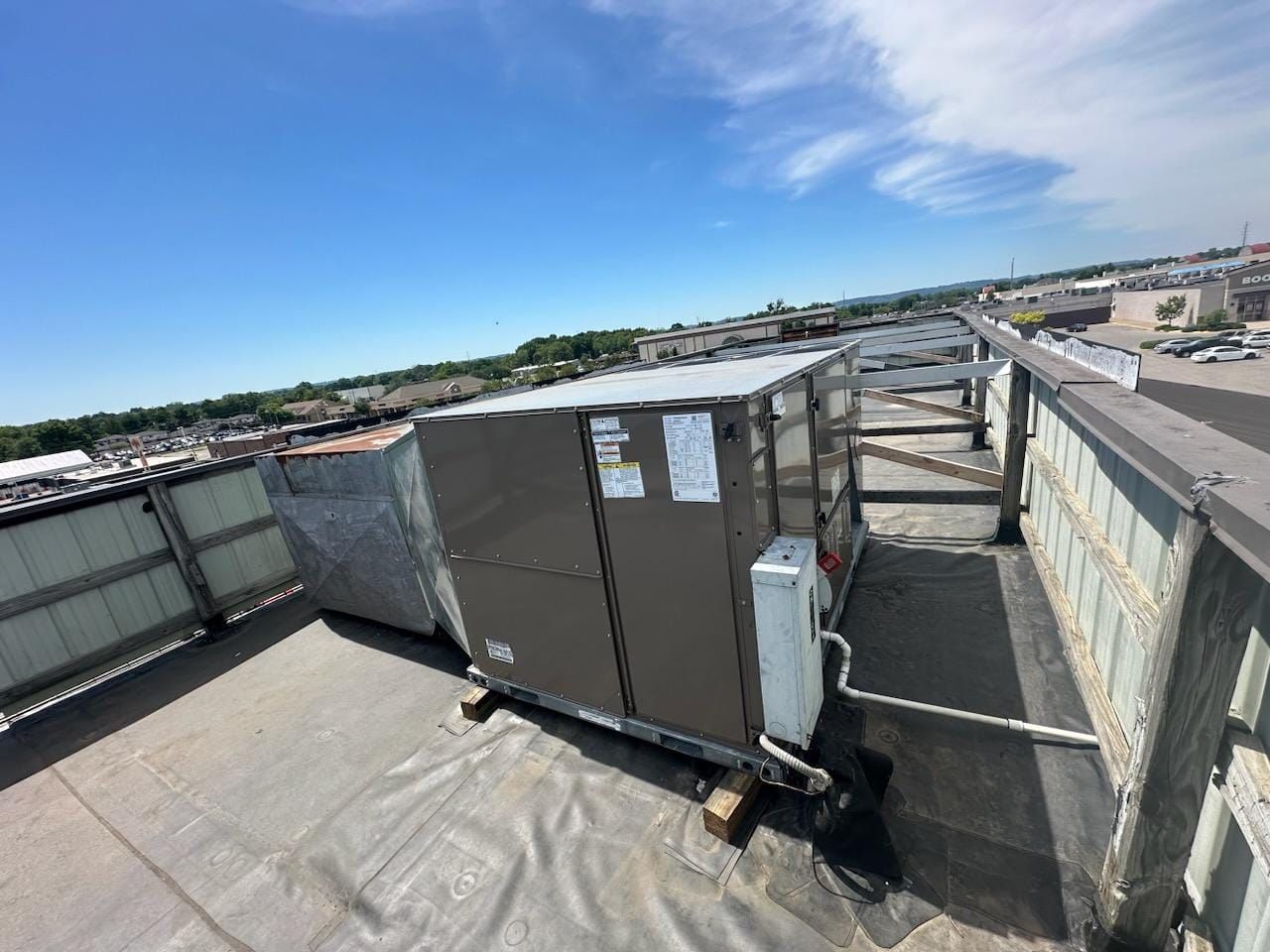A large air conditioner is sitting on the roof of a building.