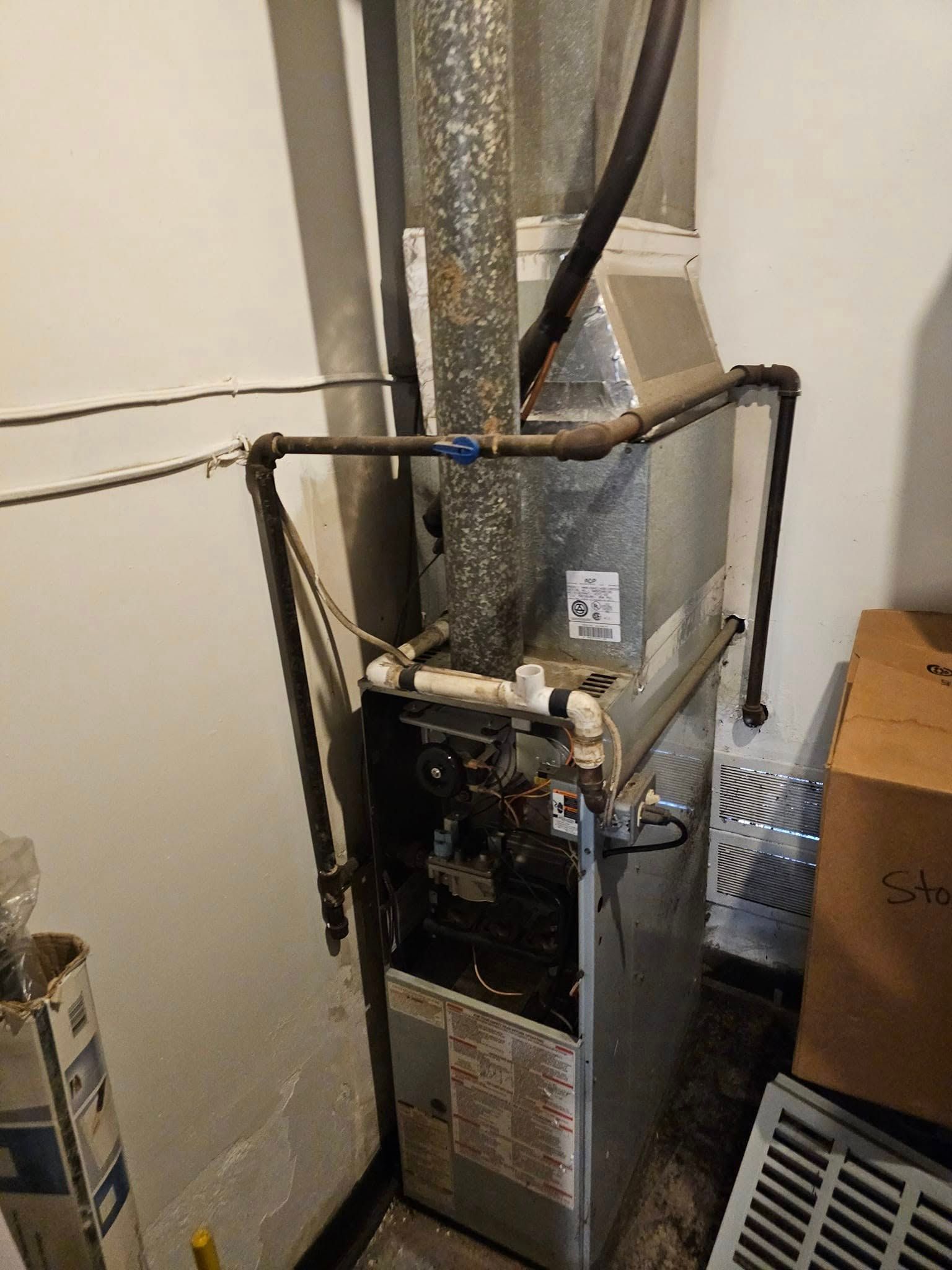 A furnace is sitting in a room next to a wall.
