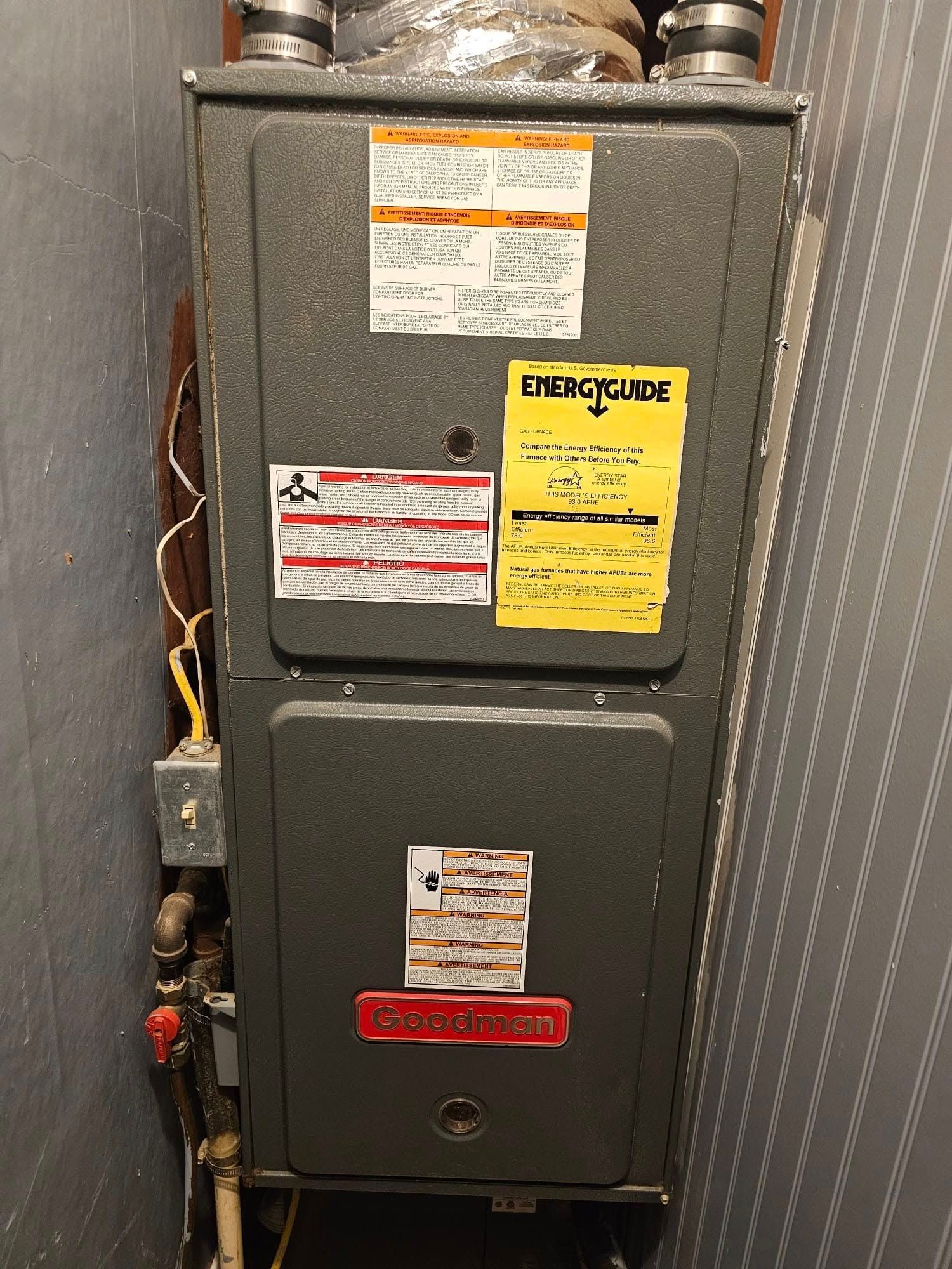 An air conditioner is sitting in a corner of a room next to a wall.