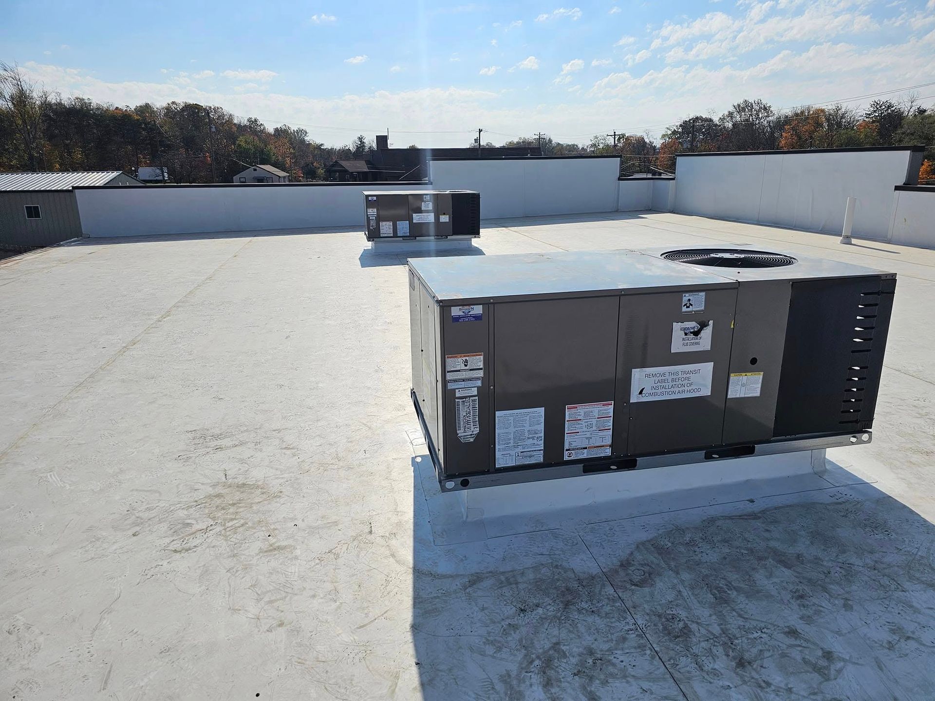A large box is sitting on top of a white roof.
