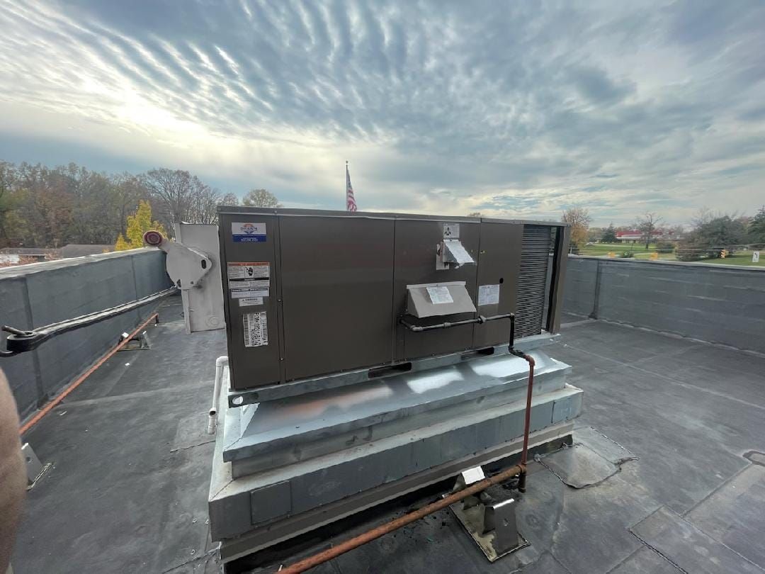 A large air conditioner is sitting on top of a roof.