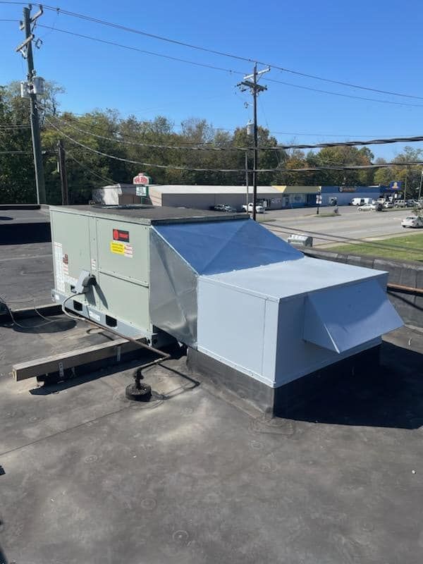 A large air conditioner is sitting on top of a roof.
