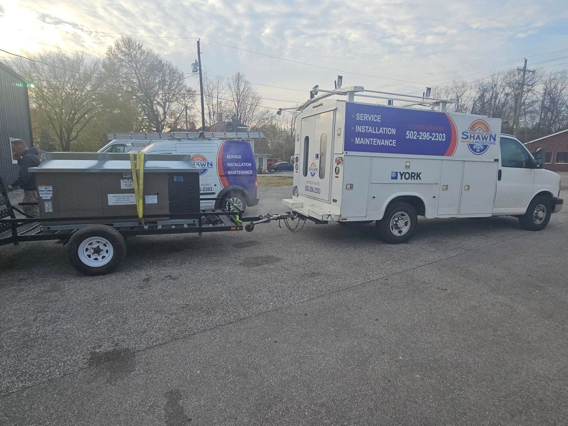 A white van is pulling a trailer with a hot tub on it.