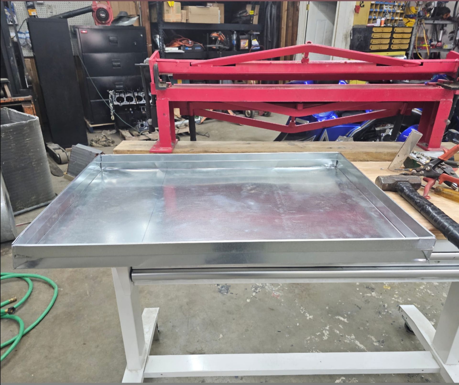 A metal tray is sitting on a table next to a machine