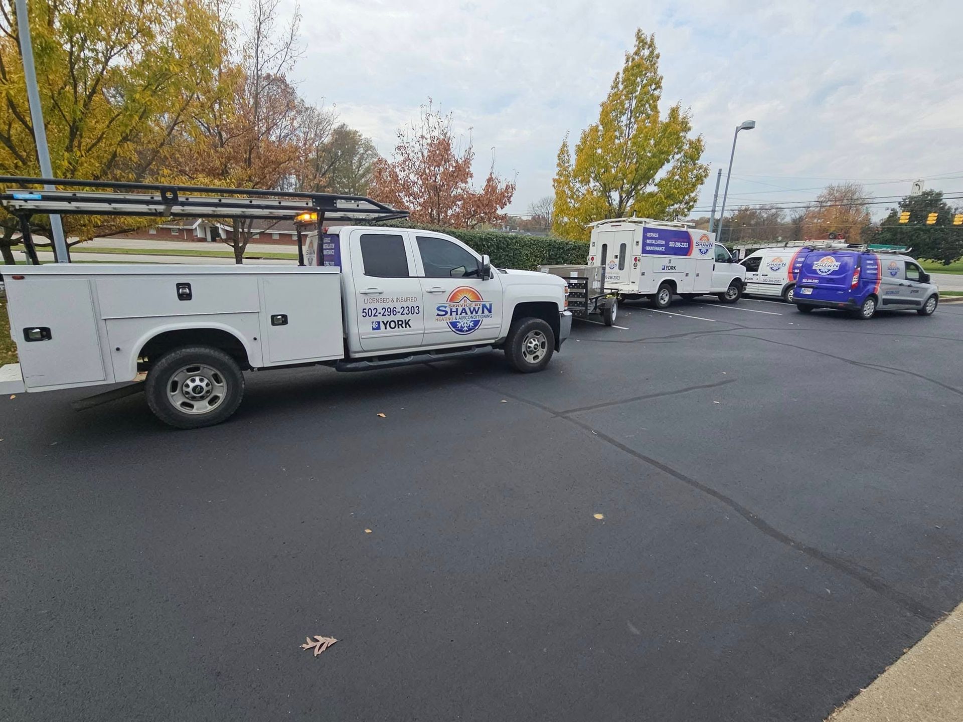 A white truck is parked in a parking lot next to a blue van.