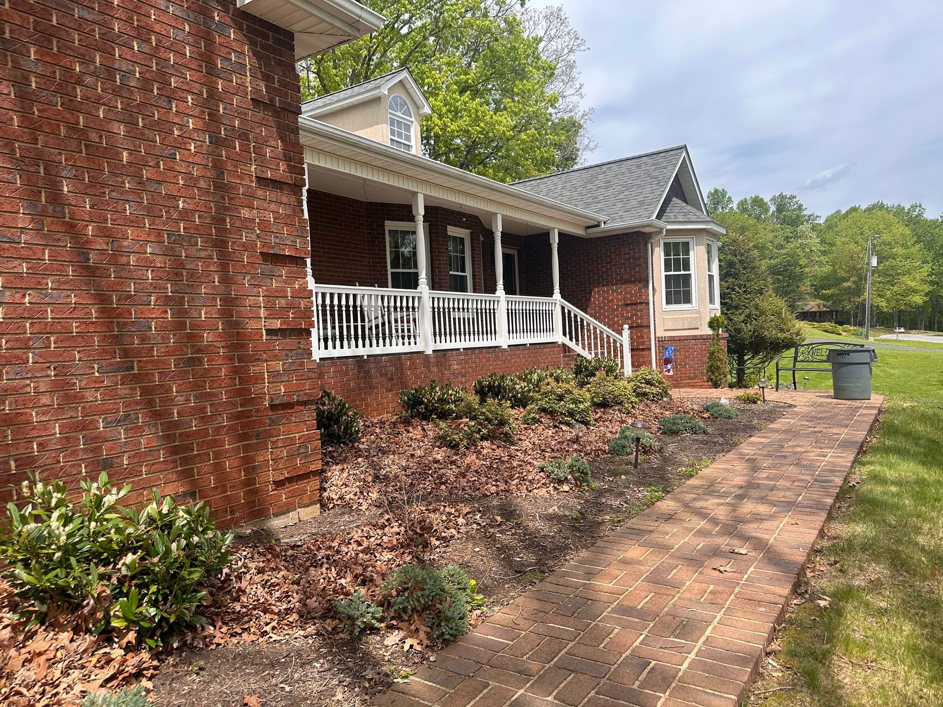 Brick building with a porch, walkway, and landscaping.