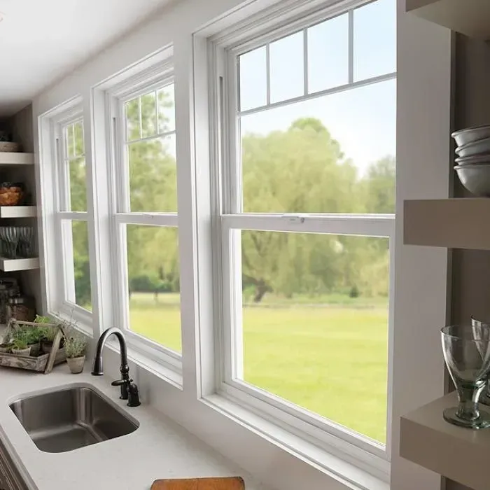 A kitchen with a sink and a window with a view of a field