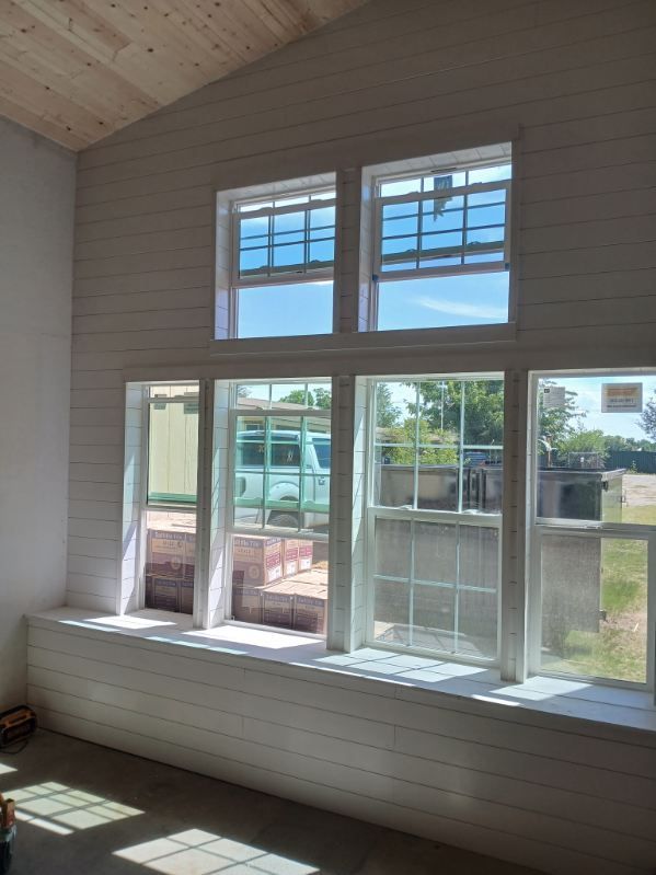 Interior with white-paneled walls, large windows, and a built-in bench seat.