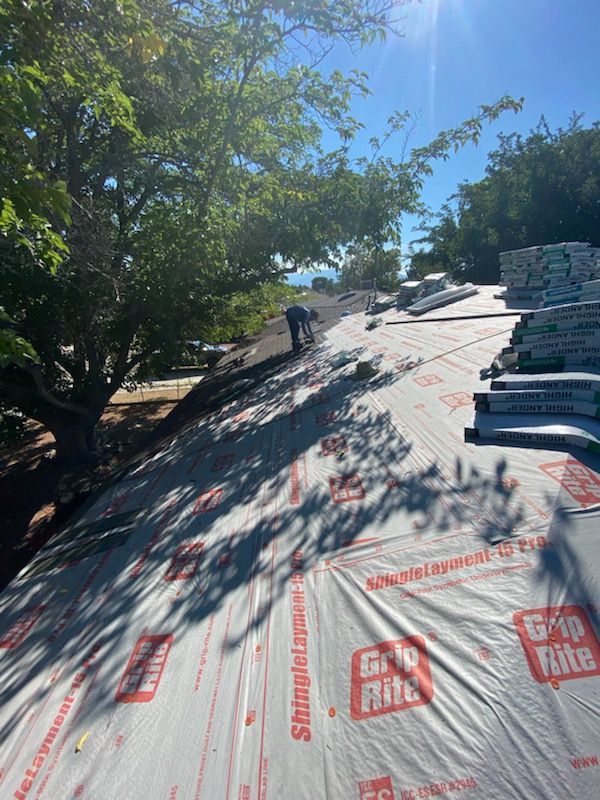 Person working on a rooftop, materials and sunlight present.