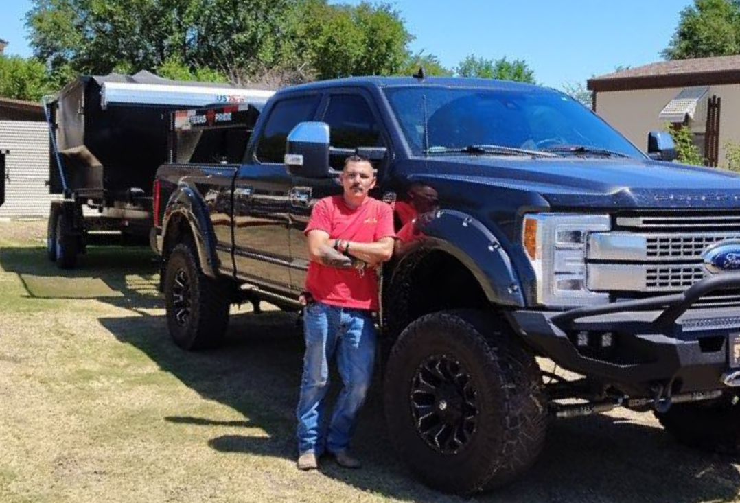 A remodeled kitchen with blue cabinets, stainless steel appliances, light countertops, and wood flooring.