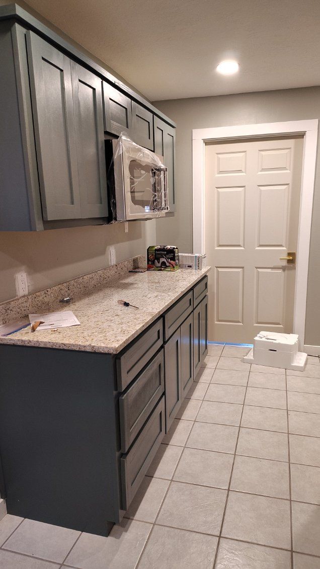White and tiled bathroom vanity with arched opening, ceramic vessel sink, and gold faucet.