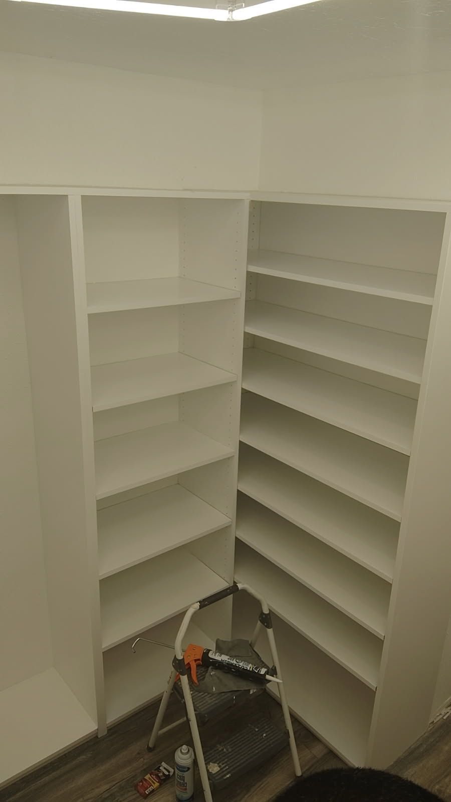 A white truck is parked in a parking lot next to a building.