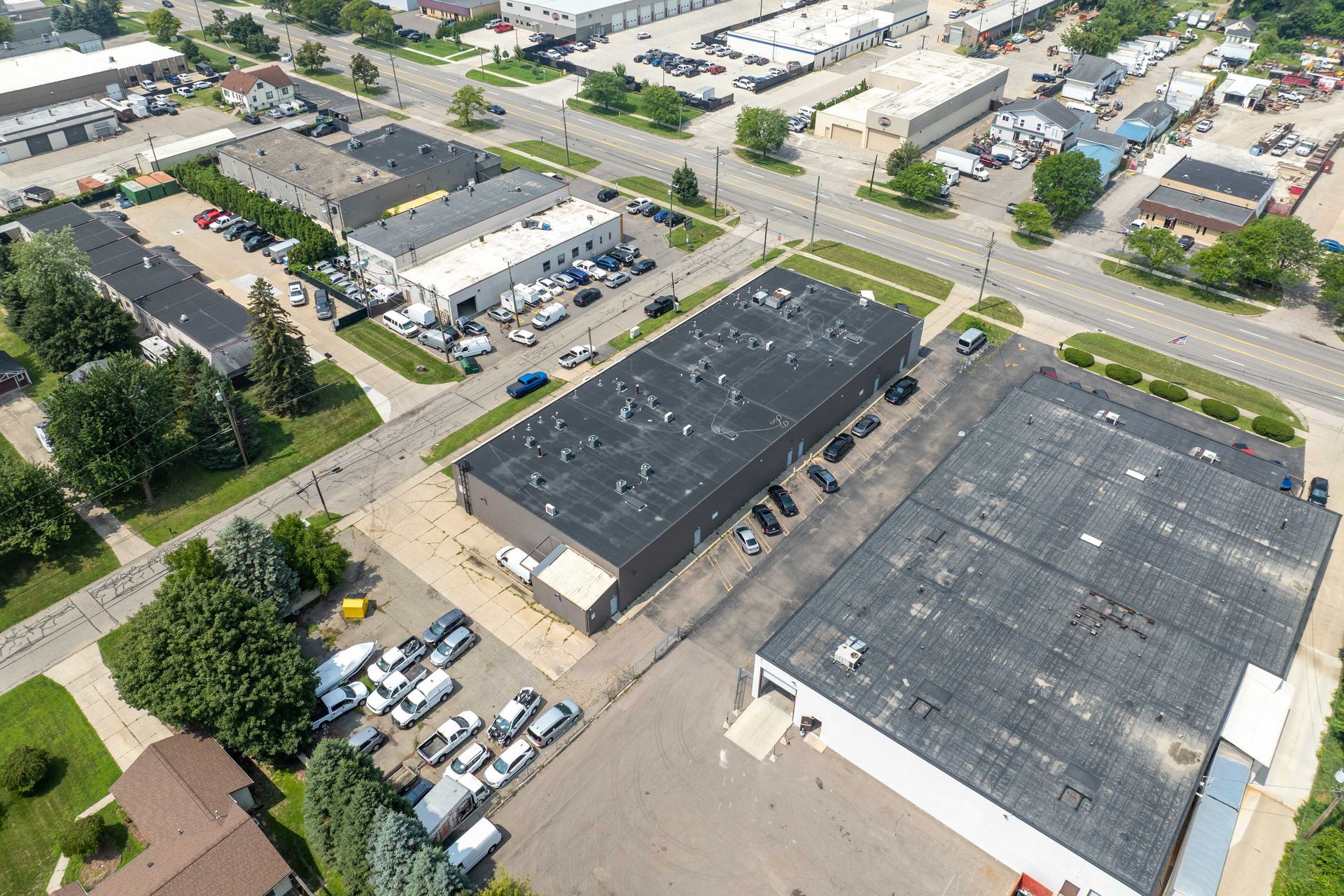 Aerial view of industrial buildings with parking areas and surrounding streets.