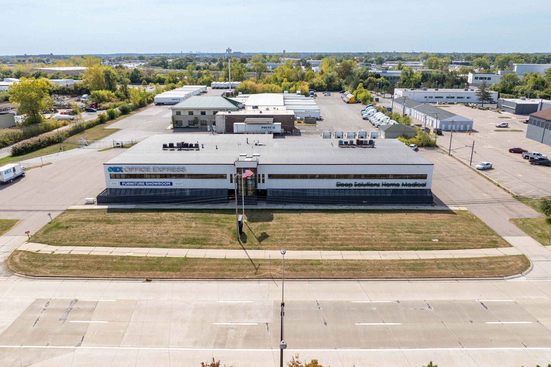 A large, two-story commercial building with signage, in a business district.