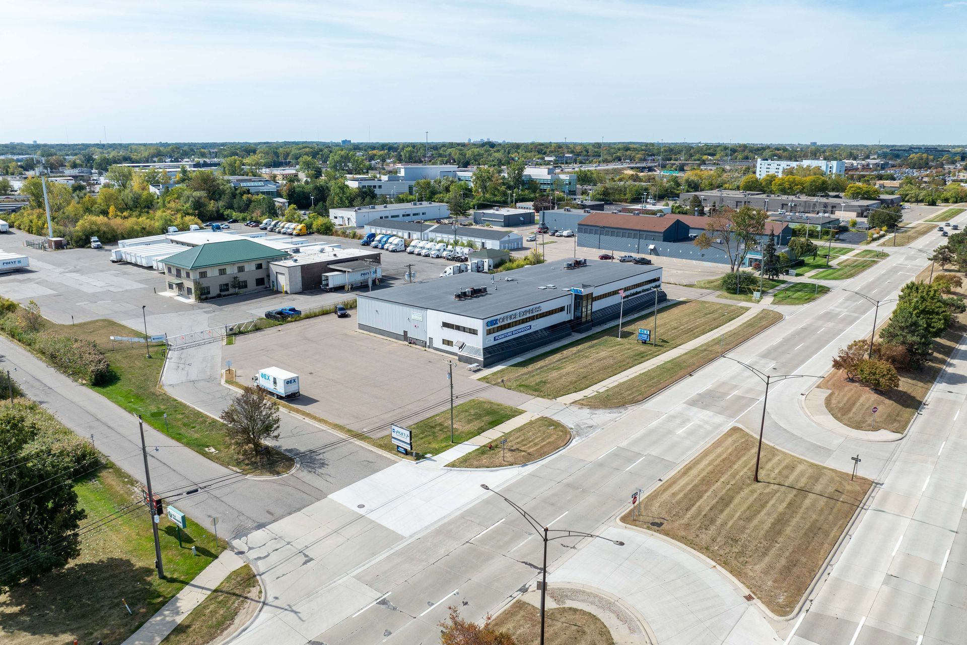 Aerial view of an urban area with buildings and roads under a blue sky.