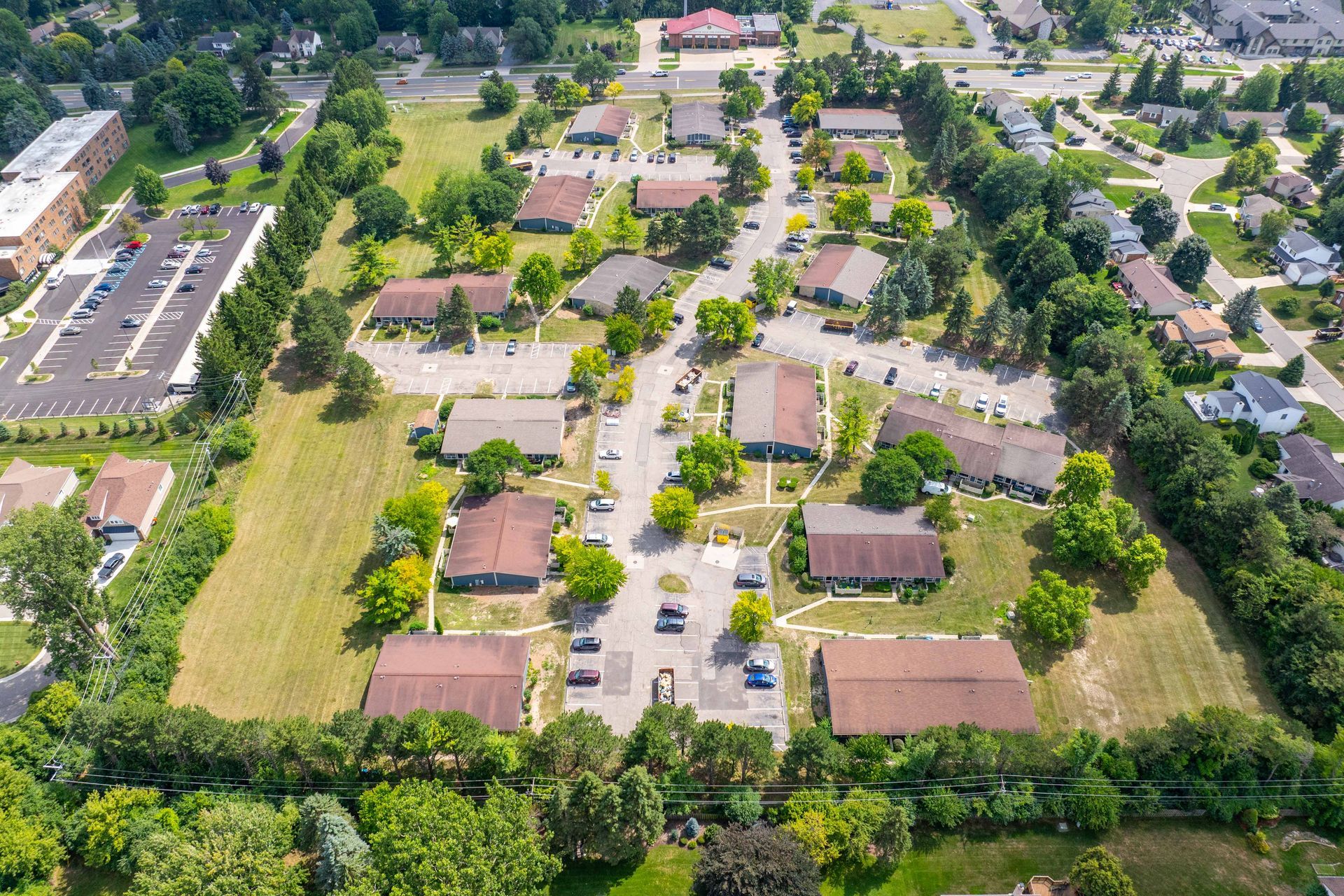 Aerial view of a residential neighborhood with several single-story buildings and surrounding trees.