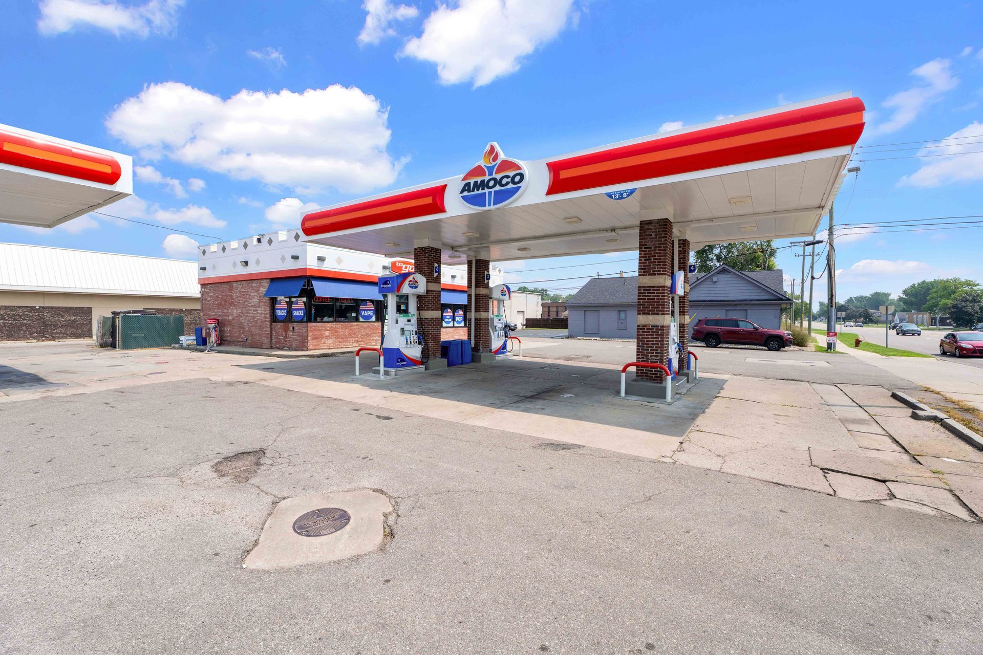 Gas station with red and white canopy, blue sky.