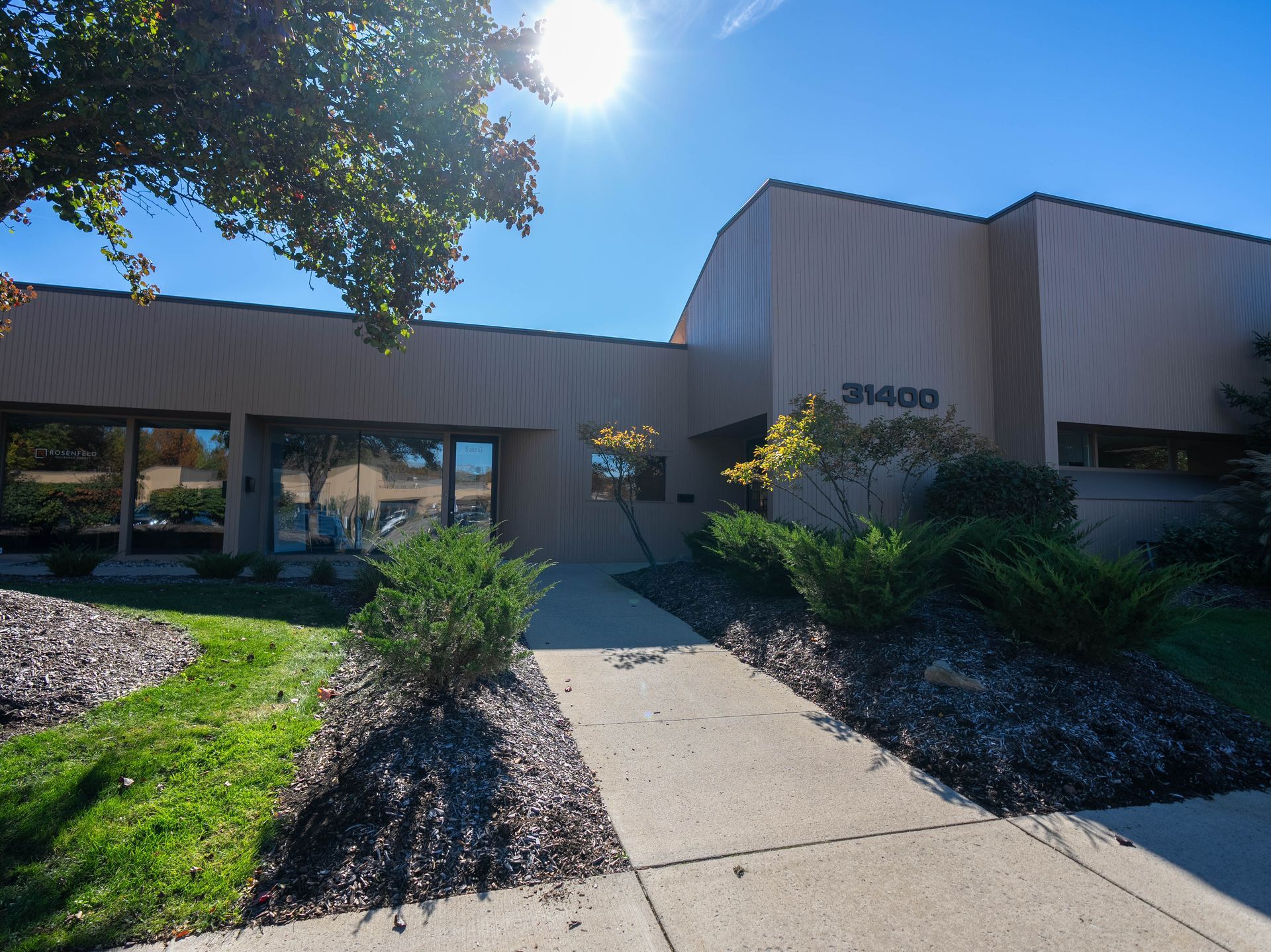 Beige building with a pathway and landscaping; sunny day. Address is 31400.