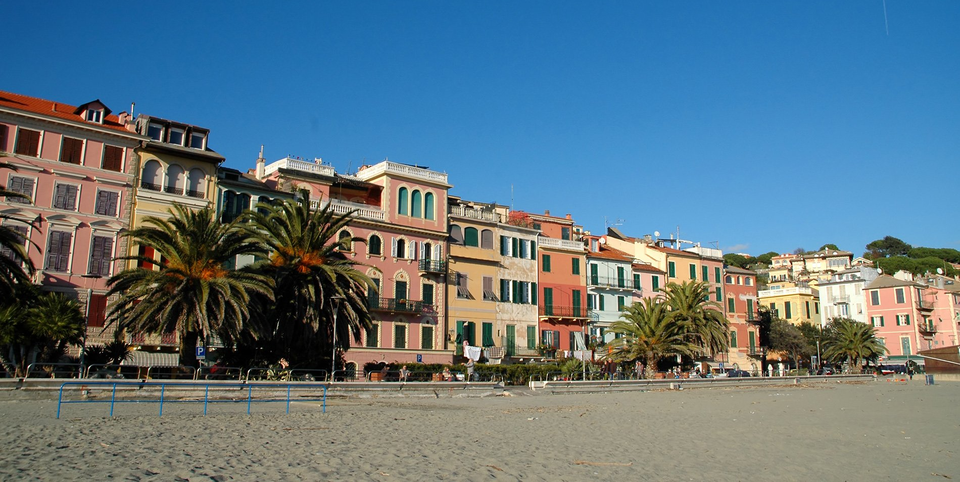 Una spiaggia con una fila di edifici sullo sfondo